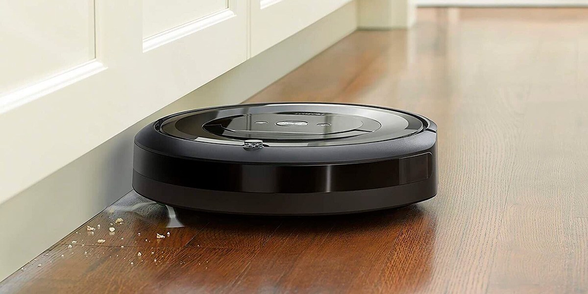 Roomba e5 on hardwood floor next to wall