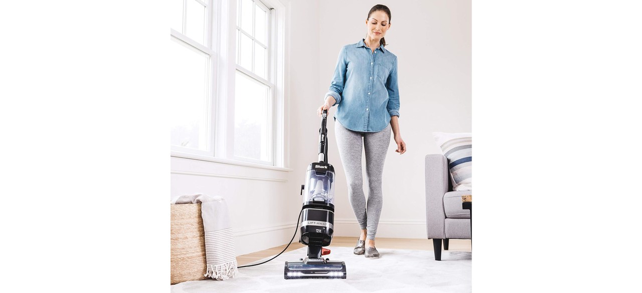 Person cleaning living room carpet with Shark LA322 Navigator ADV Corded Vacuum Lift-Away