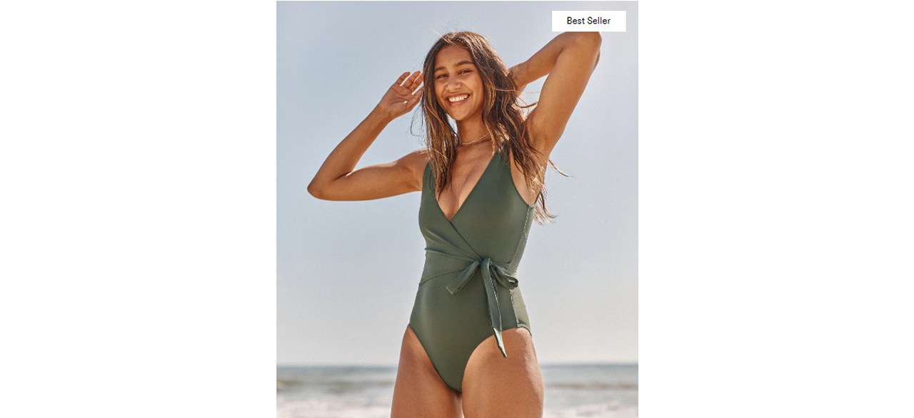 Woman on beach wearing The Perfect Wrap One-Piece