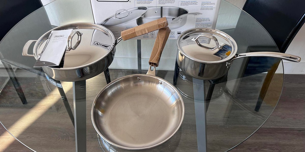 Stainless steel cookware set on glass table