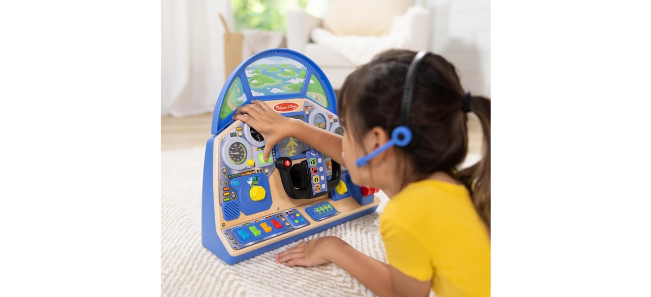 Little girl playing with Melissa & Doug Pilot Dashboard