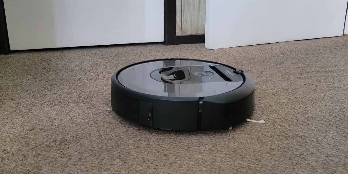 Roomba robot vacuum cleans beige carpet