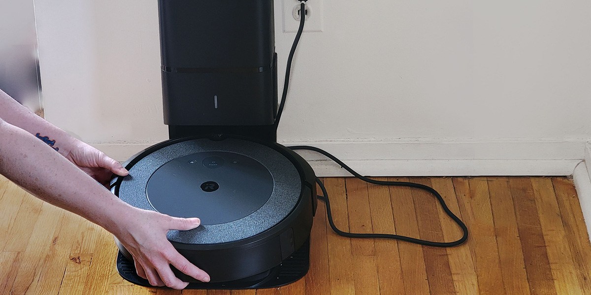 Person removing Roomba's dustbin while on charging dock