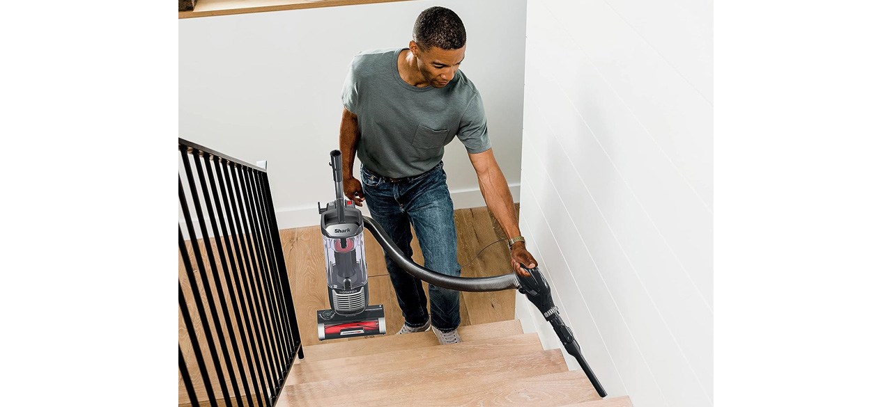 Person cleaning stairs with Shark Rotator Pet Upright Vacuum with PowerFins HairPro and Odor Neutralizer Technology