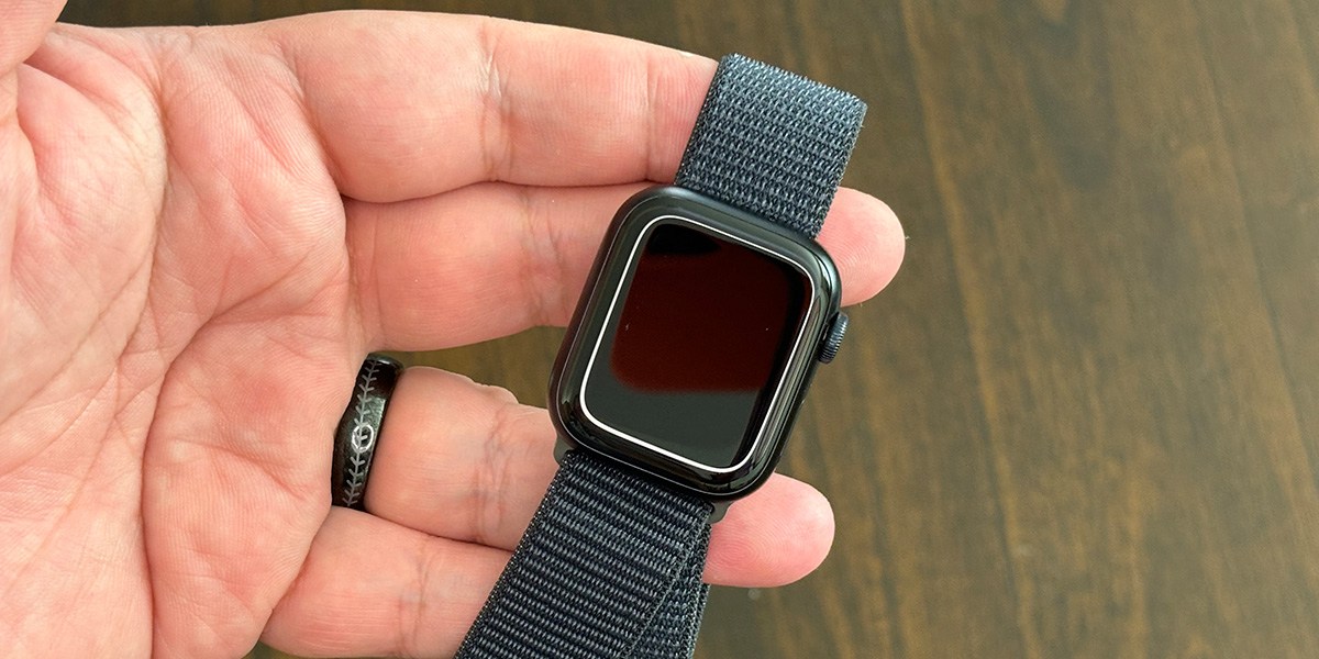 Hand holding Apple Watch Series 9 specs