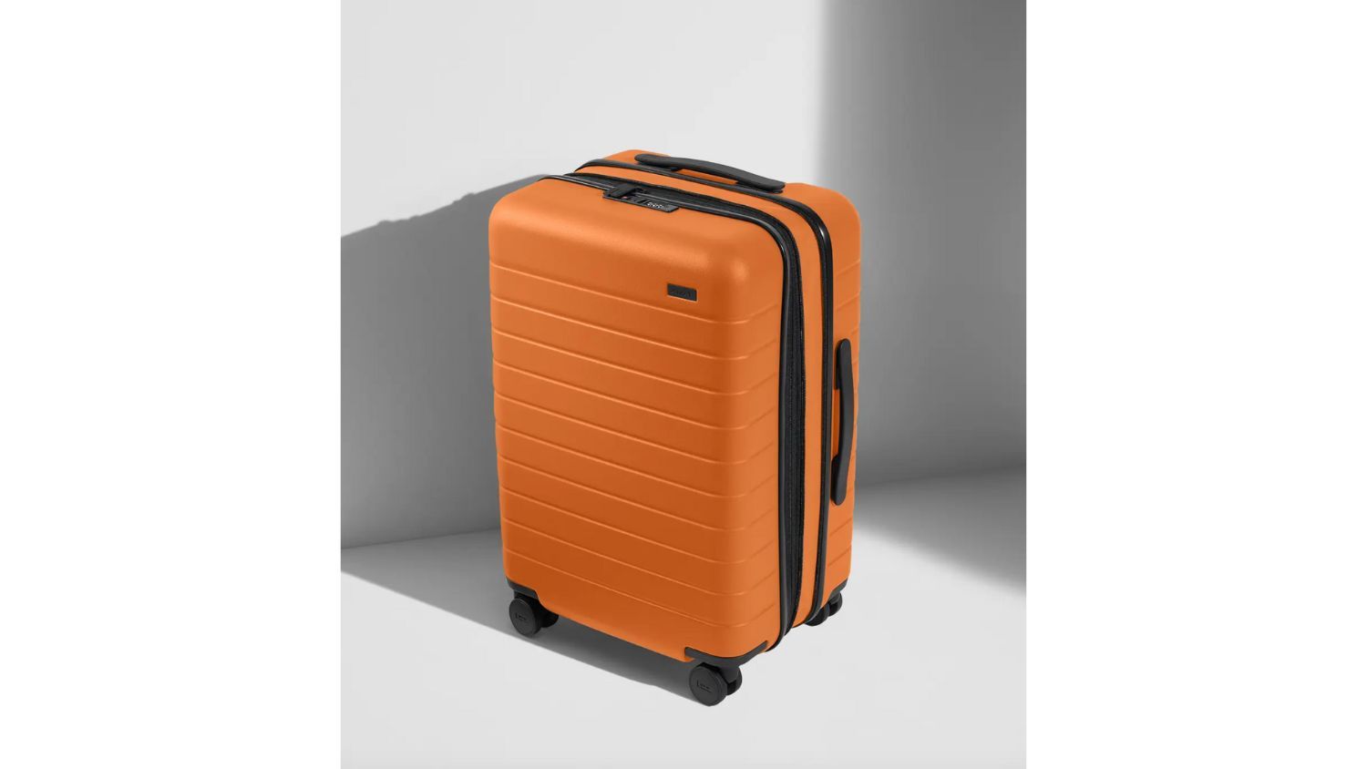 orange suitcase on gray background with shadow