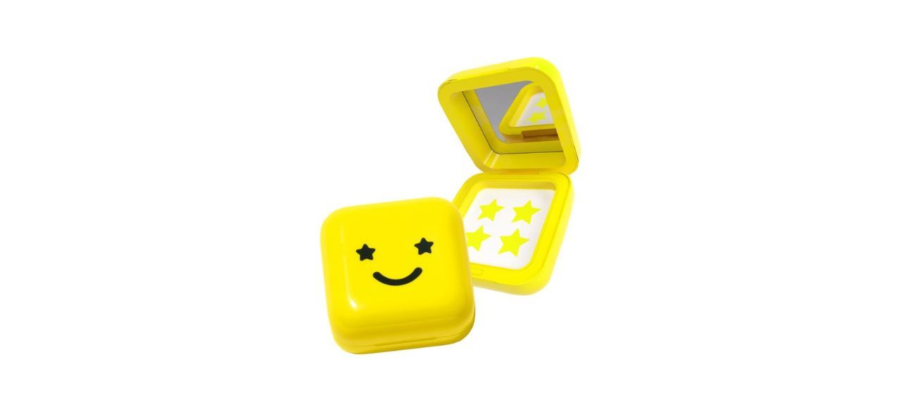 yellow pimple patches shaped like stars, next to a yellow holding case with a smiley face with eyes that are stars