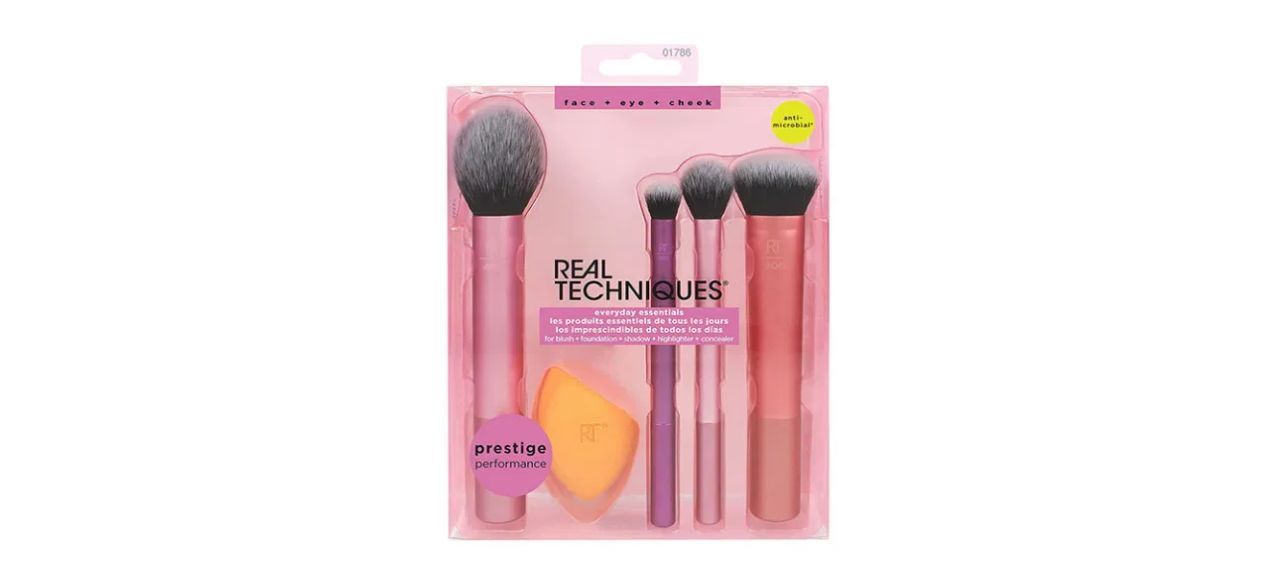 A set of makeup brushes with four different sizes of brushes and a small orange sponge blender.