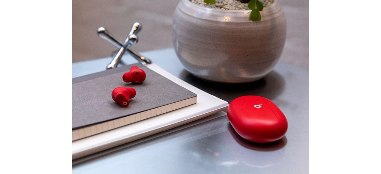 Red Beats Studio Buds on table next to planter