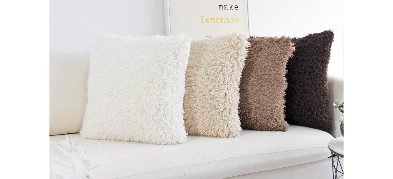 Four different-colored JOJUSIS Fluffy Decorative Throw Pillows with Covers on sofa