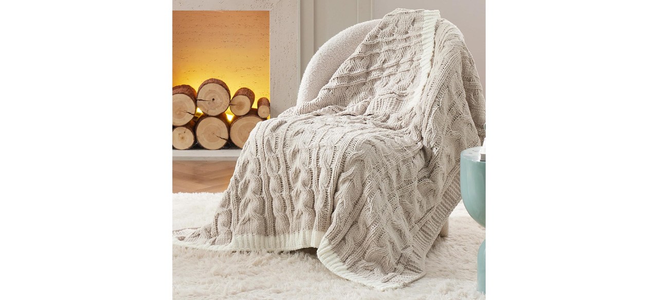 Bedsure Cable Knitted Throw Blanket draped on chair next to fireplace