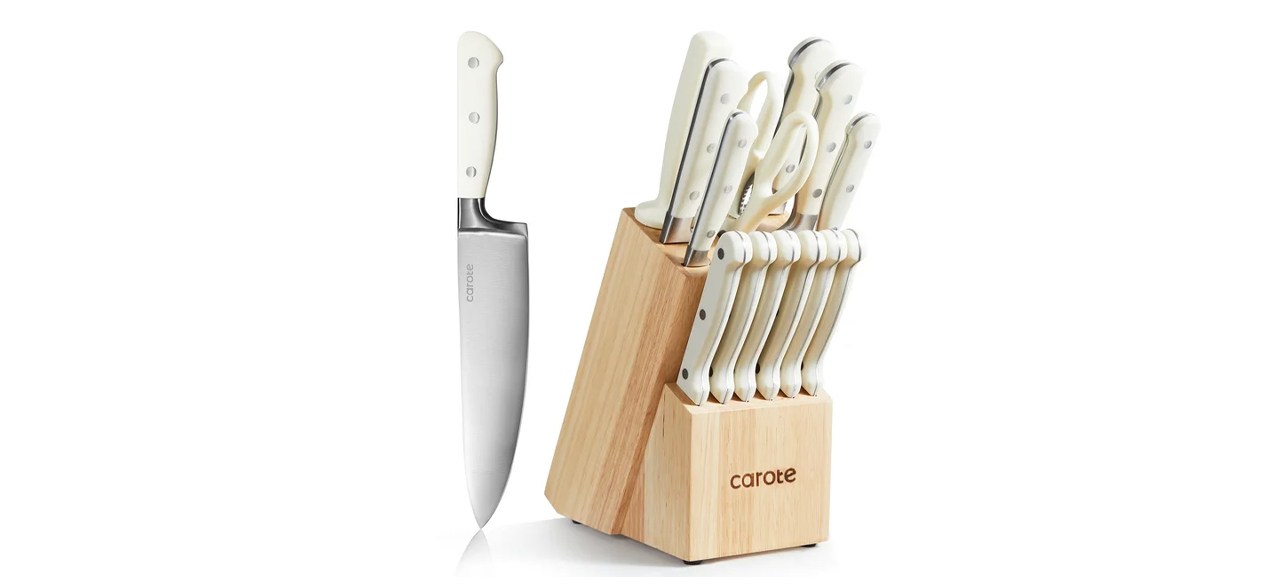 A 14-piece knife set in a wooden block with one knife on the side of the wooden block.