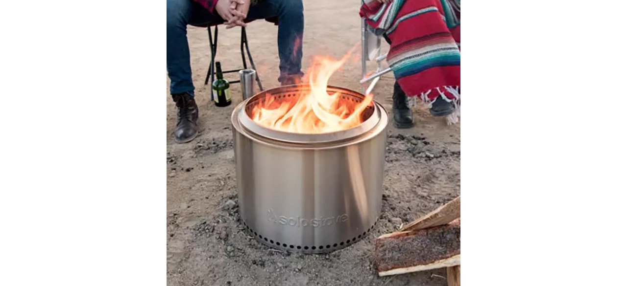 Group of people gathered around Solo Stove Bonfire 2.0 on beach