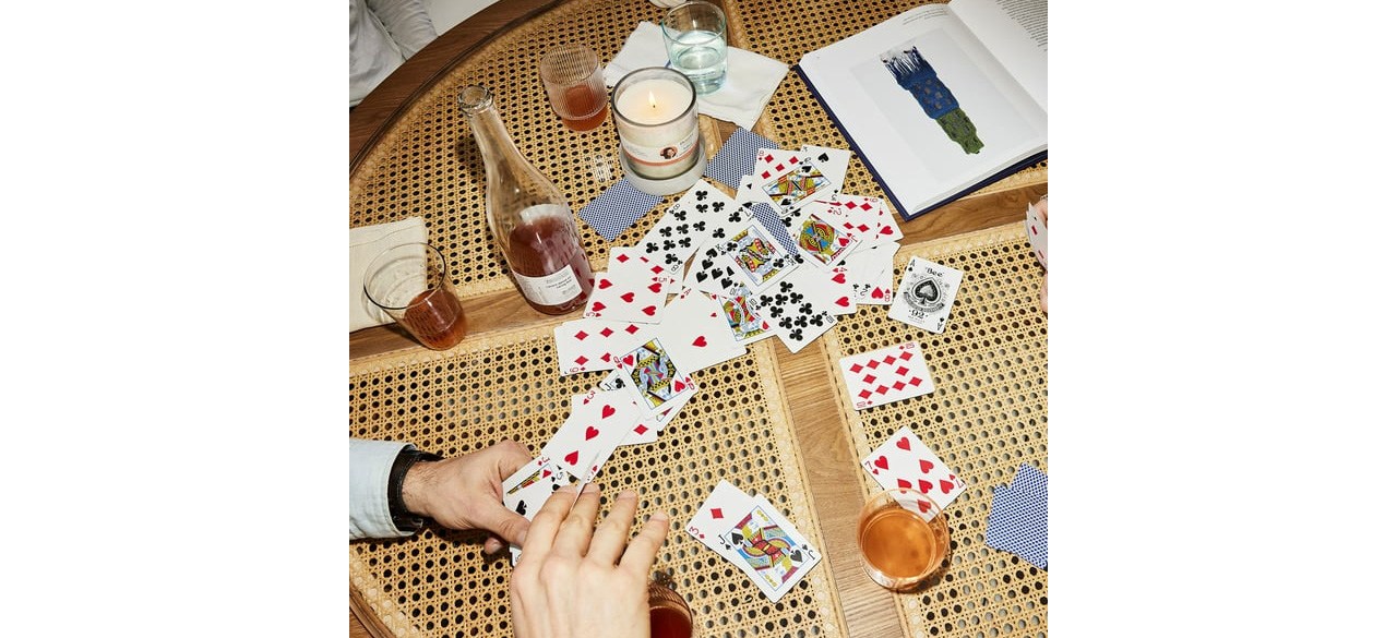 People playing cards on a beautiful wicker and glass coffee table