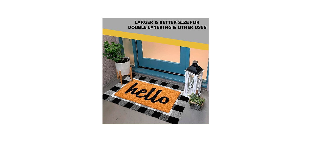 An orange rug that says "hello" on it and has a black and white buffalo plaid border