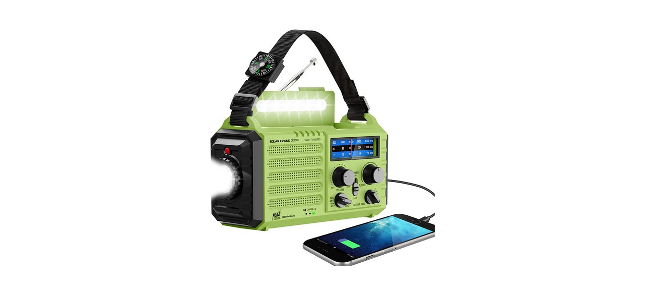 A green radio with lots of knobs on it with a smartphone plugged into it.