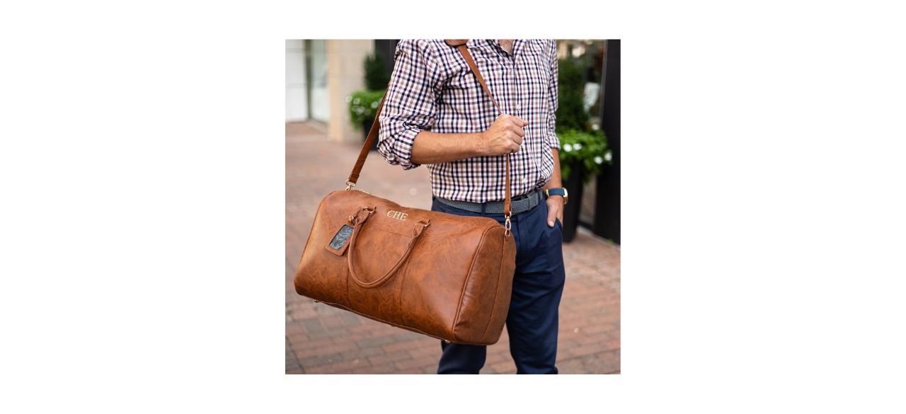 Man carrying TheManRegistry Maverick Men's Brown Leather Duffel Bag