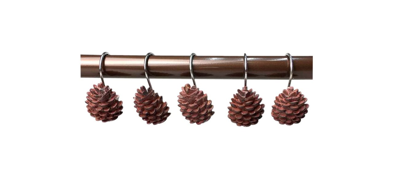 5 shower hooks with fake pinecones on them