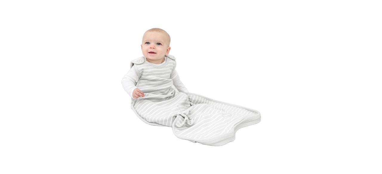 A really cute baby wearing a gray sleep sack with white stripes on it.