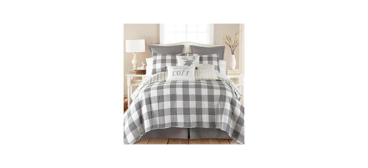 A gray and white buffalo plaid comforter with matching pillow shams on a bed