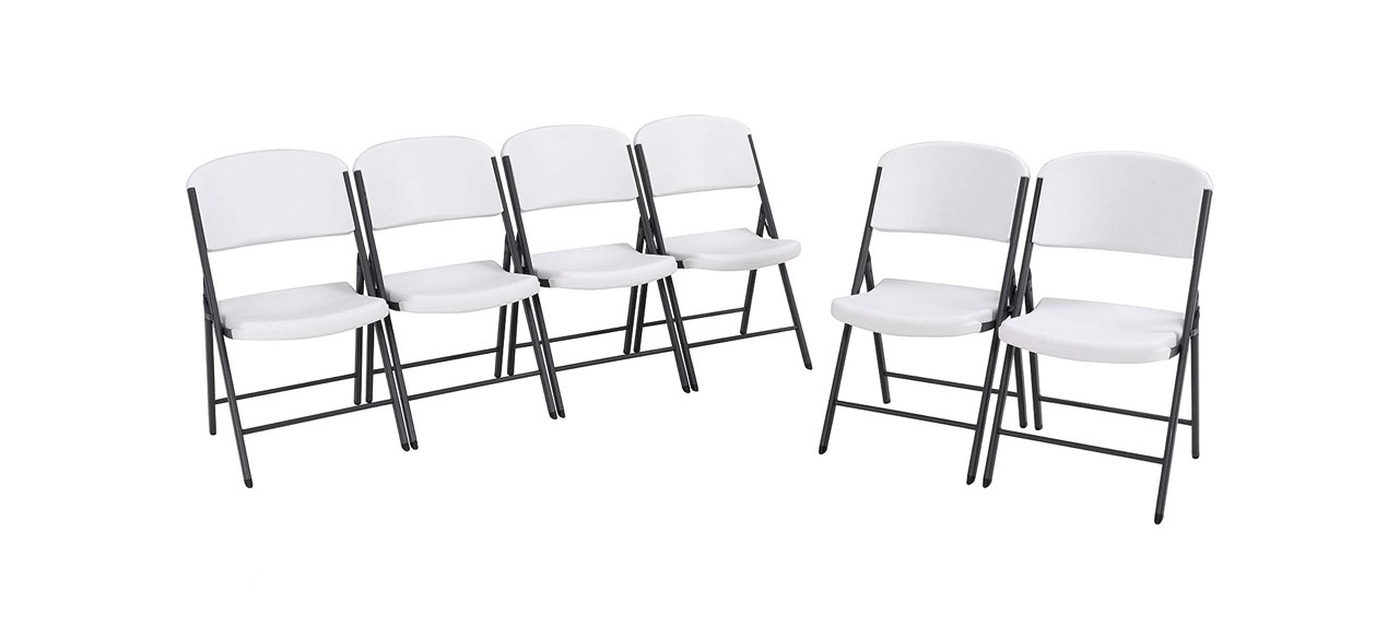 a set of white plastic chairs with metal frame