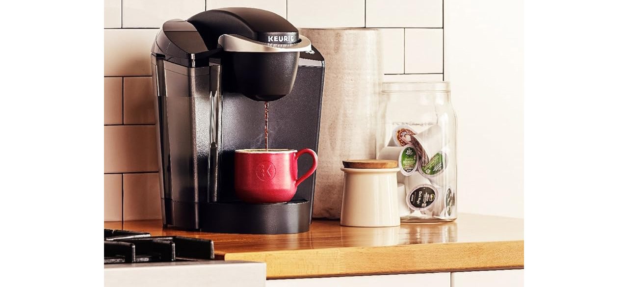 Black Keurig K-Classic Coffee Maker with red cup on countertop