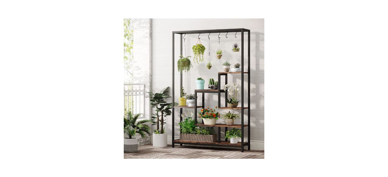 a large plant stand with multiple shelves. It looks almost like a bookshelf but with hooks for hanging plants.