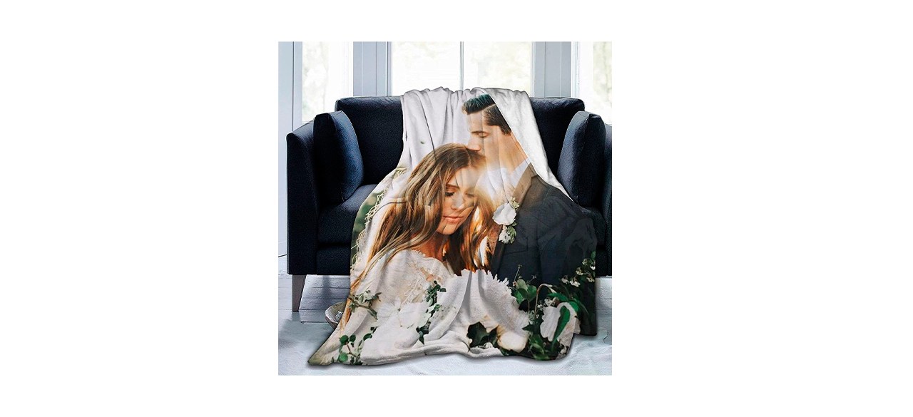 A custom photo blanket draped across a black chair