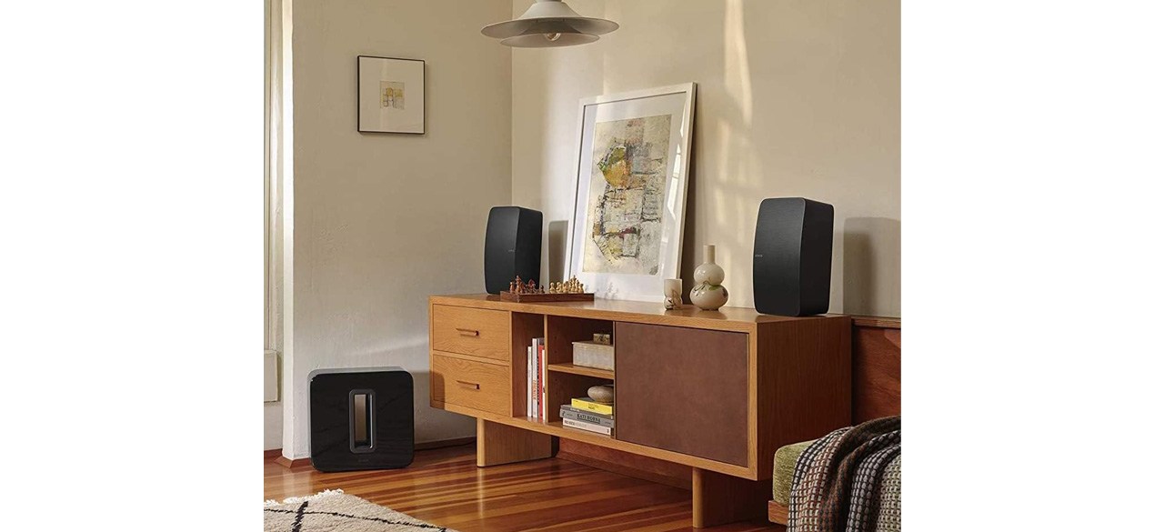 Two Sonos Five speakers on cabinet next to picture