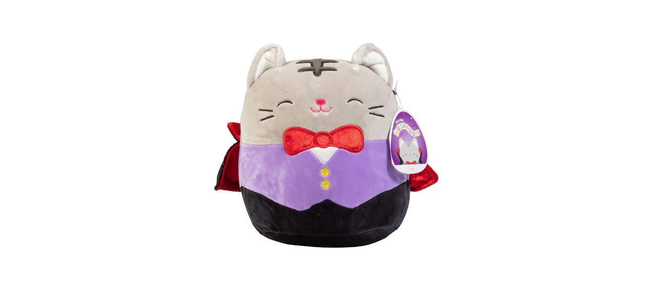 A smiling gray cat plushie wearing a purple vest, red bowtie, and red/black vampire cape