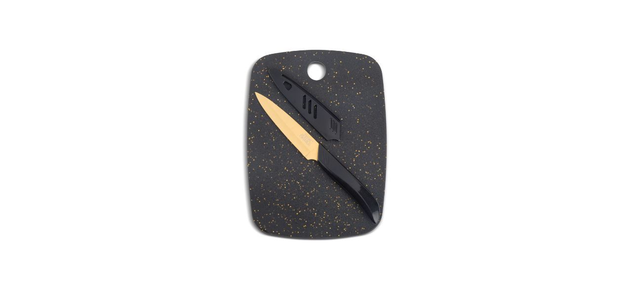 a black cutting board with gold sparkles and a knife with a gold-colored blade