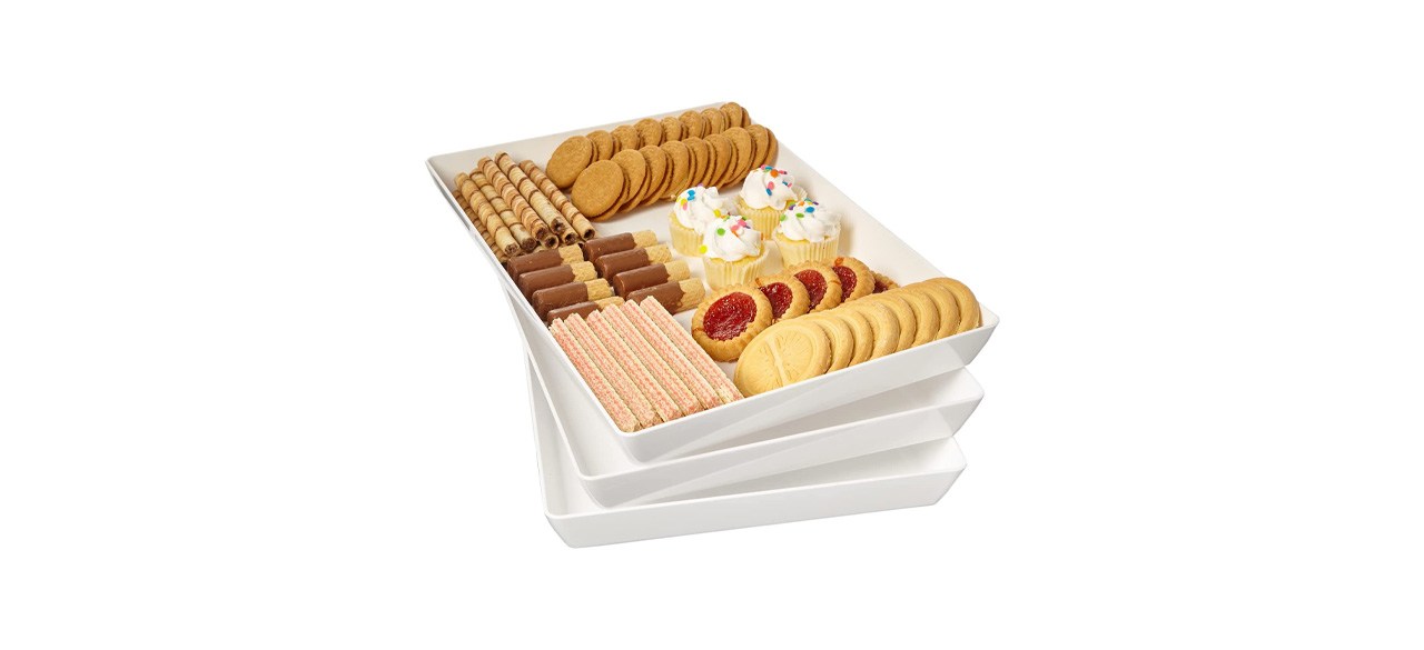 3 stacked white plastic rectangular serving platters; one has snacks on it