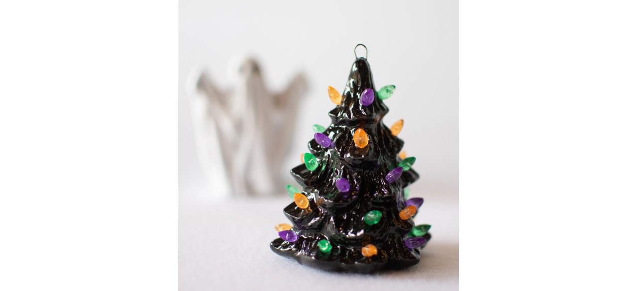 Mini ceramic Halloween tree on table with ghost in background