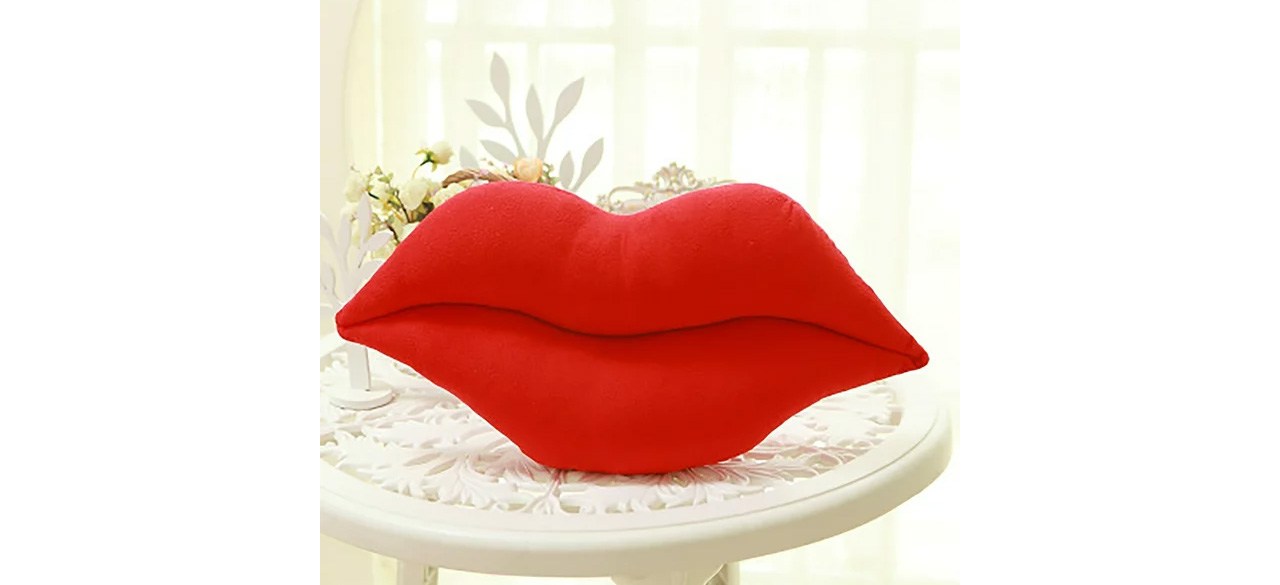 Pompotops Decorative Pillows Lips Plush Toys on table in front of plant