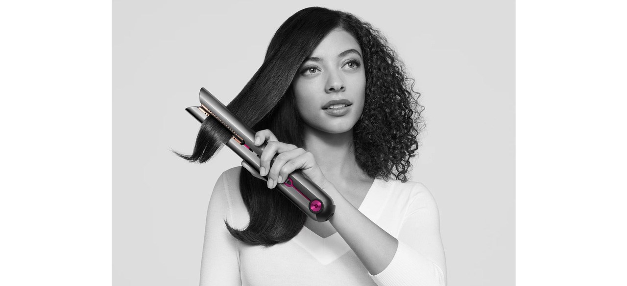 Woman using Dyson Corrale straightener