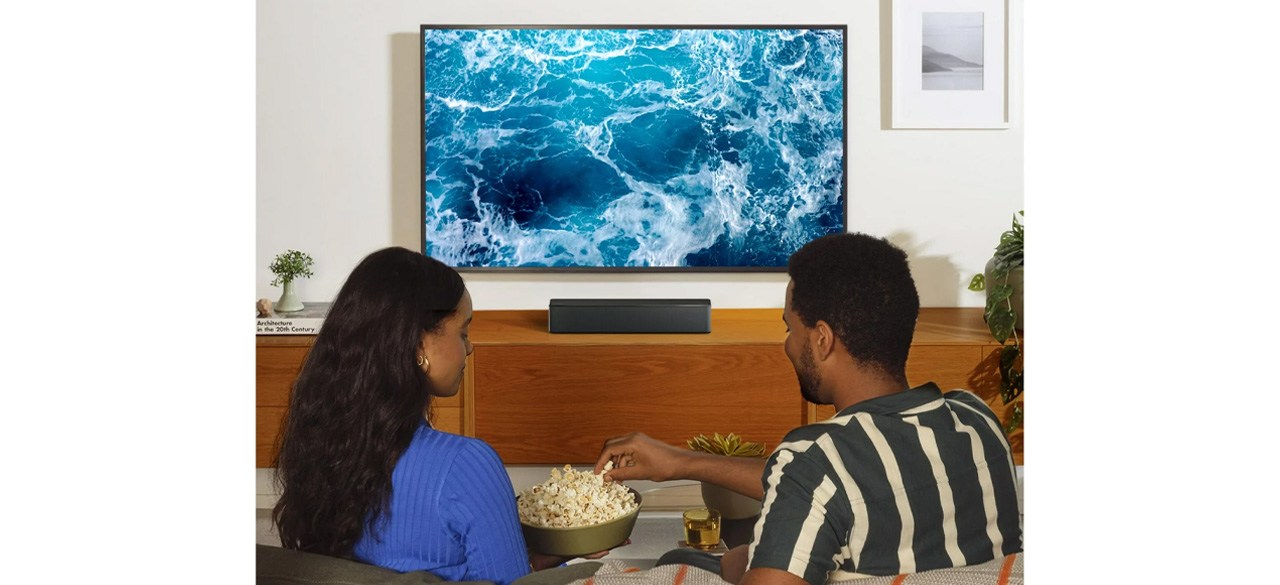 ULTIMEA 5.1 Dolby Atmos Two people eating popcorn in front of the TV with a soundbar in front of them