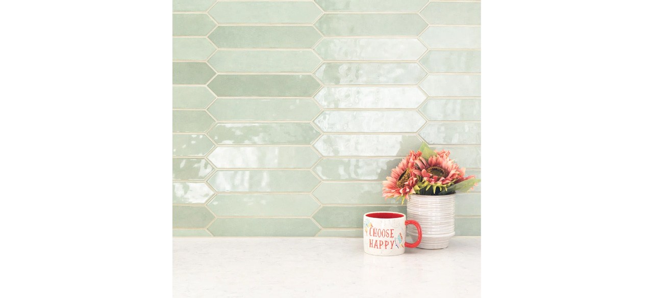 Green MSI Renzo Glossy Ceramic Picket Wall Tile with plant and coffee cup in front