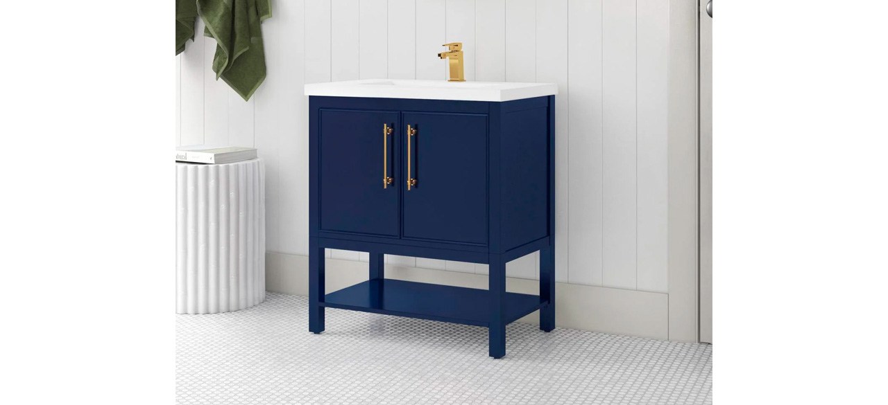 Blue and white bathroom vanity with gold faucet and handles