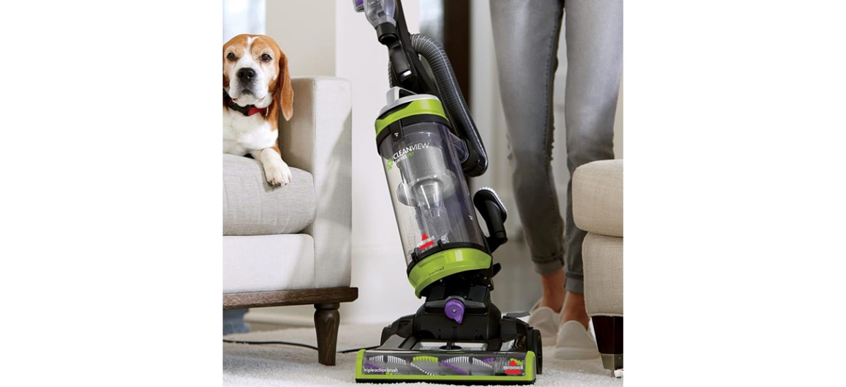 Person using BISSELL 2252 CleanView Upright Bagless Vacuum with dog sitting on sofa in background Person using BISSELL 2252 CleanView Upright Bagless Vacuum with dog sitting on sofa in background