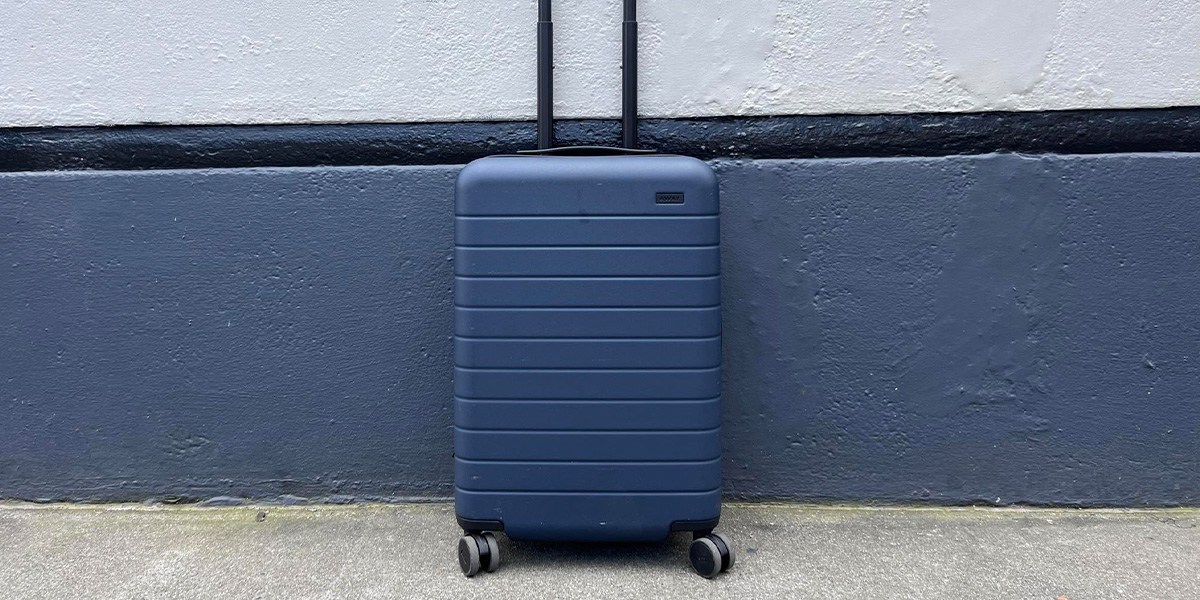 Blue carry-on in front of wall