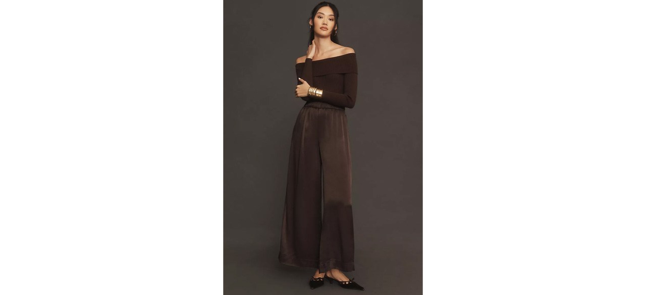 Woman wearing By Anthropologie Off-The-Shoulder Twofer Jumpsuit on dark background