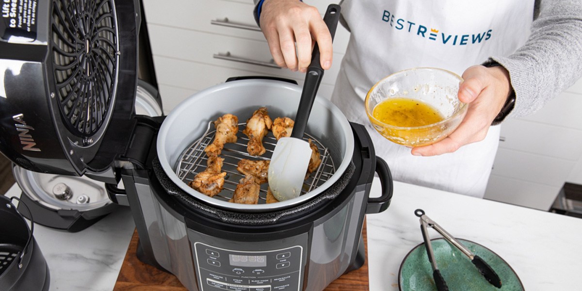 Person cooking chicken wings in air fryer