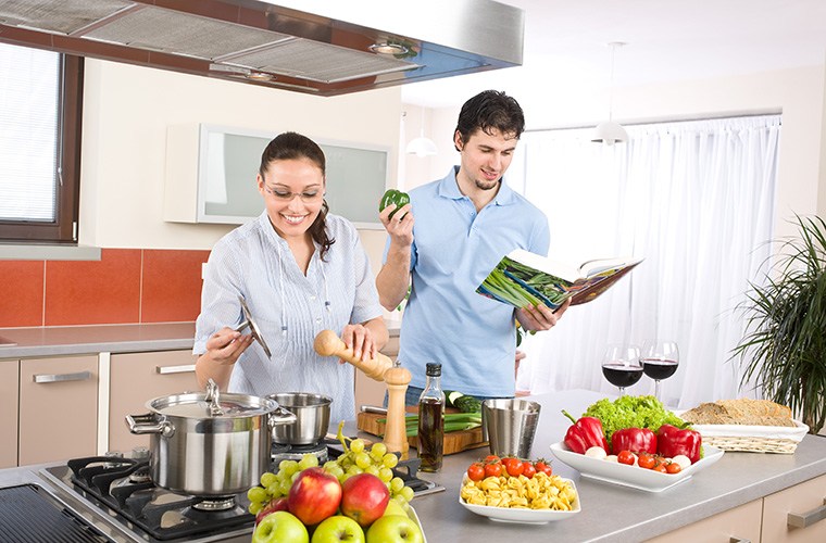 a couple cooking with a cookbook