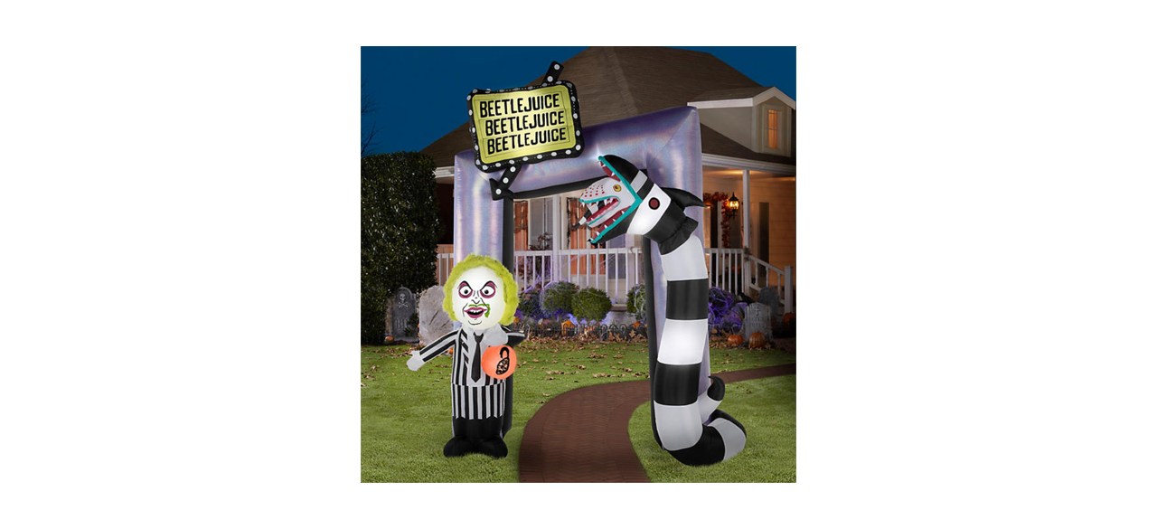 A Beetlejuice10.5-foot Airblown Inflatable Archway on a lawn in front of a house