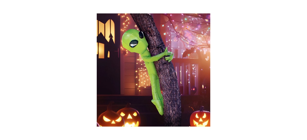 A Syncfun 4-foot Halloween Inflatable Alien Tree Ghost Inflatable on a tree.