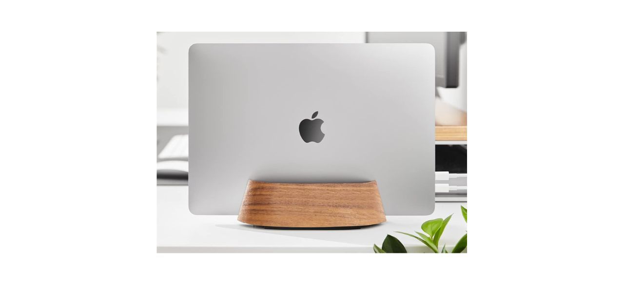 a wooden laptop holder holding a Macbook laptop computer