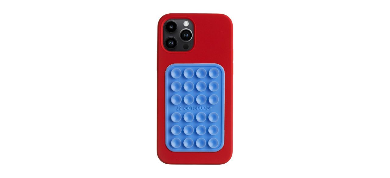 a blue rectangular silicone suction phone mount shown on a red iPhone