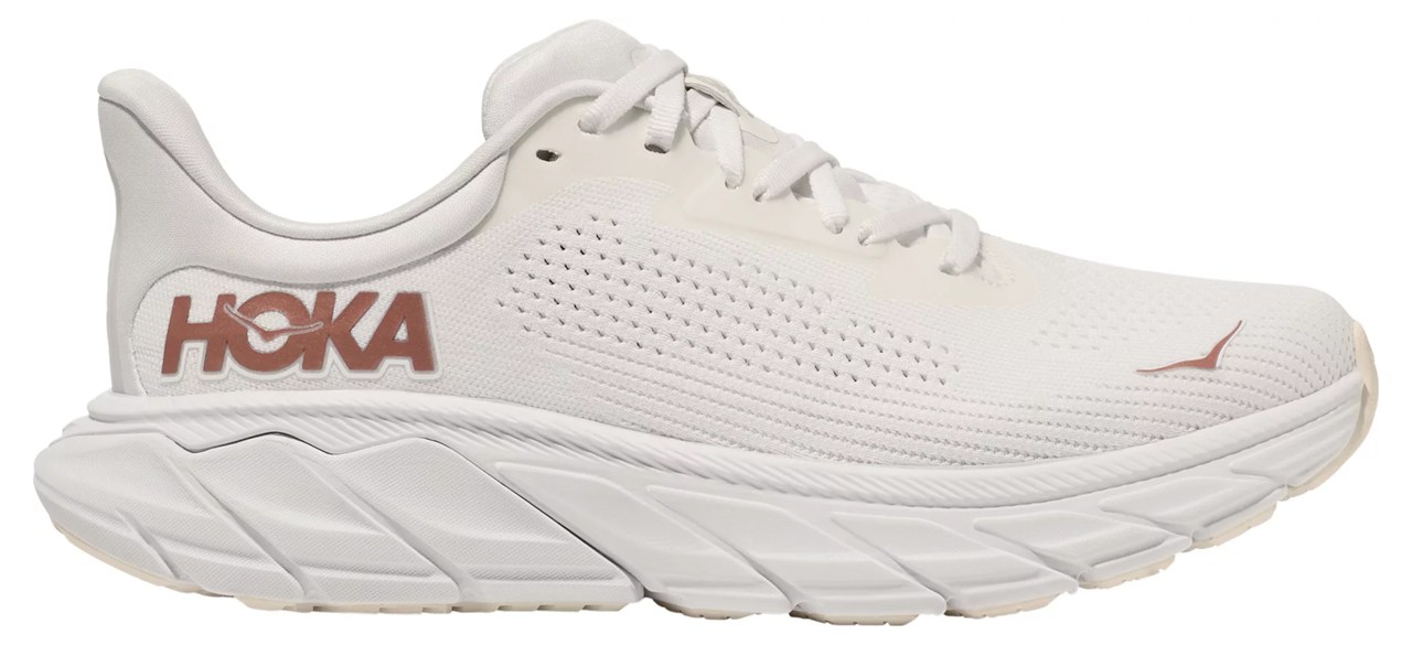 A white Hoka sneaker with rose gold accents.