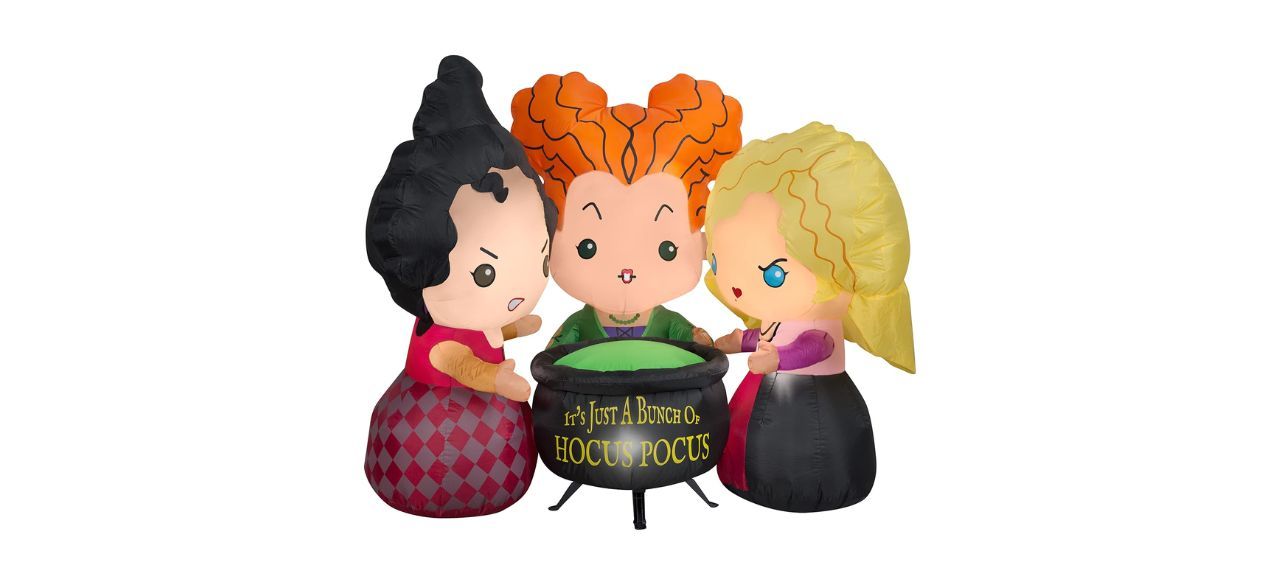 Outdoor inflatables of the Sanderson sisters from "Hocus Pocus" standing around a black cauldron that says "it's just a bunch of hocus pocus"