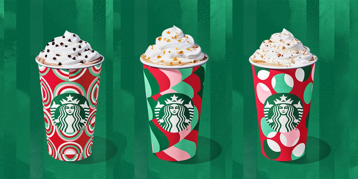 Drinks in Starbucks holiday cups with whipped cream on top